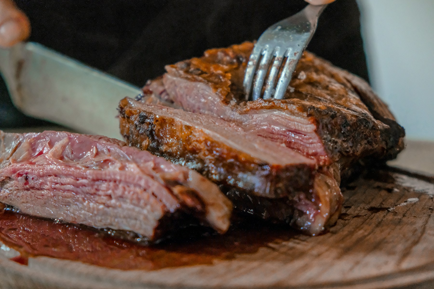 Juicy sliced steak resting on a wooden carving board