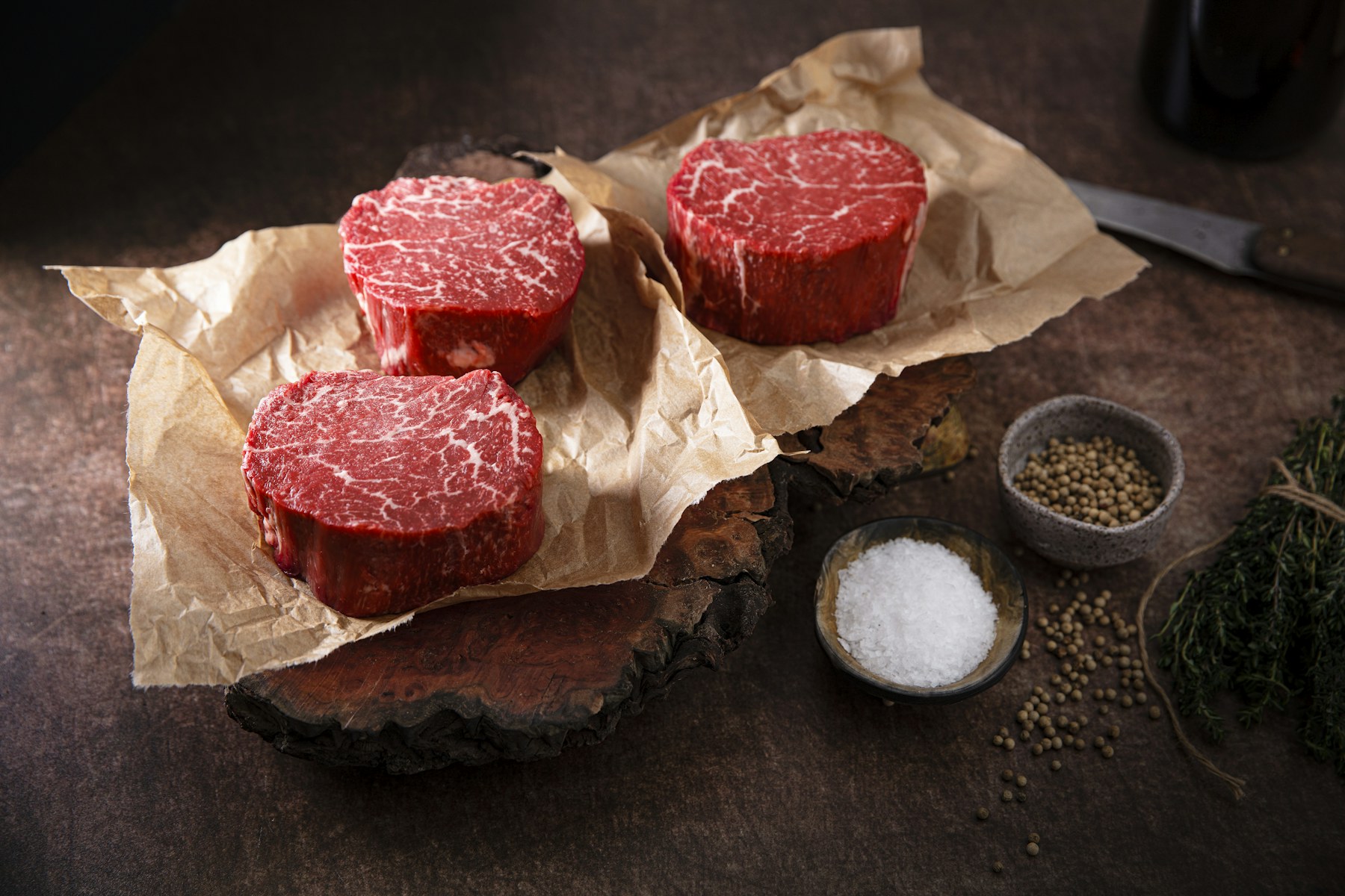 Three richly marbled raw beef filets on butcher paper